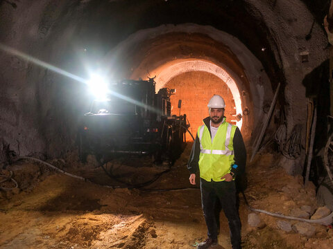 Engineer Working Inside the Tunnel with Equipment and Hard Hat