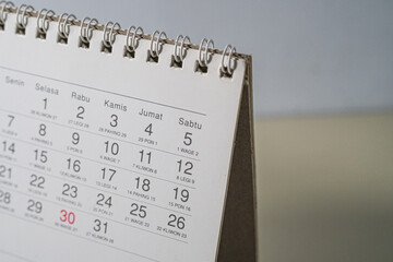 Close up of a white desk calendar showing specific date, captured from an angled macro perspective.
