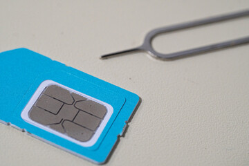 Close up macro of SIM card and SIM tray ejector tool