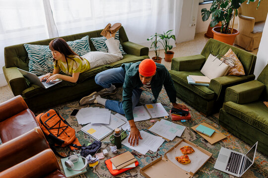 Colleagues studying at home in messy living room