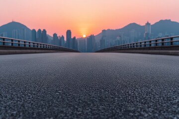 Fototapeta premium Empty asphalt highway leading to Hong Kong cityscape at sunset with mountain silhouettes and colorful sky