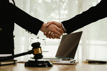 Two professionals are signing a legal agreement at a desk, with a judge’s gavel nearby. The scene reflects law, business contracts, and formal documentation.x