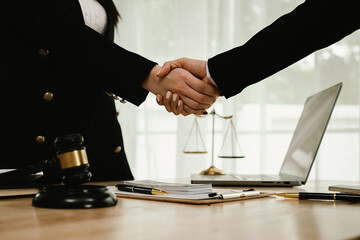 Two professionals are signing a legal agreement at a desk, with a judge’s gavel nearby. The scene reflects law, business contracts, and formal documentation.x