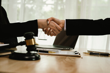 Two professionals are signing a legal agreement at a desk, with a judge’s gavel nearby. The scene reflects law, business contracts, and formal documentation.x