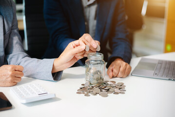 Hand putting mix coins and seed in clear bottle and business investment growth concept.