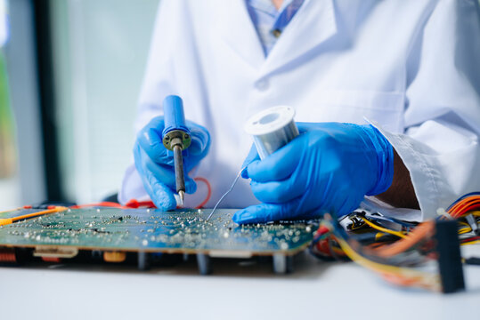 The technician repairing the motherboard in the lab with copy space. the concept of computer hardware, mobile phone, electronic, repairing, upgrade