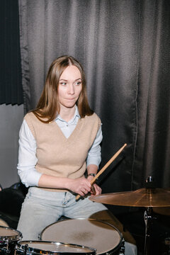 A young woman behind a drum kit.