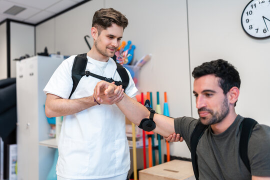 Physiotherapist assisting patient wearing sensors