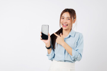 Smiling Asian woman holding a mobile phone, pointing a finger to its blank display. She is happy and excited, showing her new phone. isolated studio white background