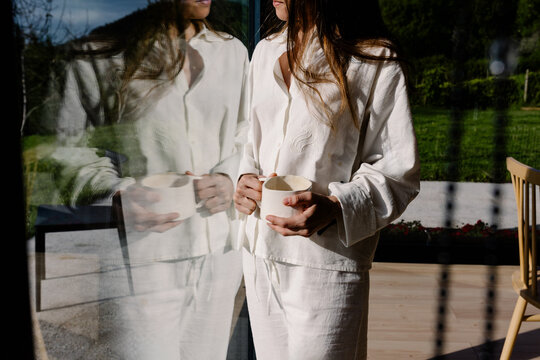 Portrait of an unknown woman standing beside her reflection