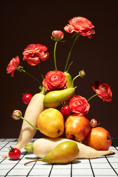 Still life with fruits, veggies and flowers on checkered tablecloth