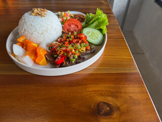 Spicy Indonesian Nasi Iga Bakar or grilled rib rice, pounded chili beef, vegetables, and condiments