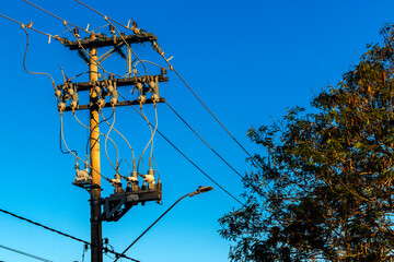 Many wires attached to the electric pole, the chaos of cables and wires on an electric pole, blue...