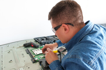 Tv repairman using a soldering iron to fix a circuit board from a modern television