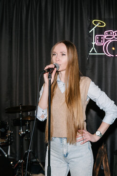 The singer performs on stage in a music studio.