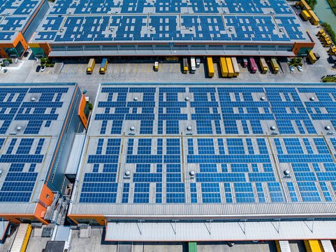 Aerial View of Factory with Solar Panels and Transport Trucks