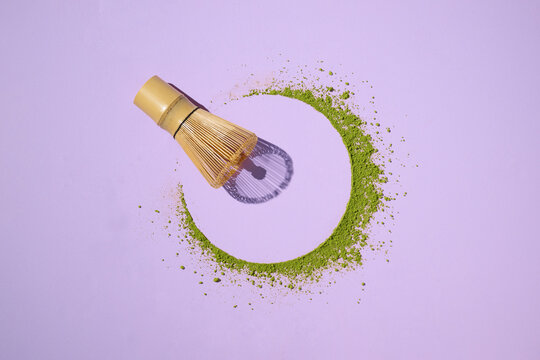 A green matcha circle created with powder and a bamboo whisk