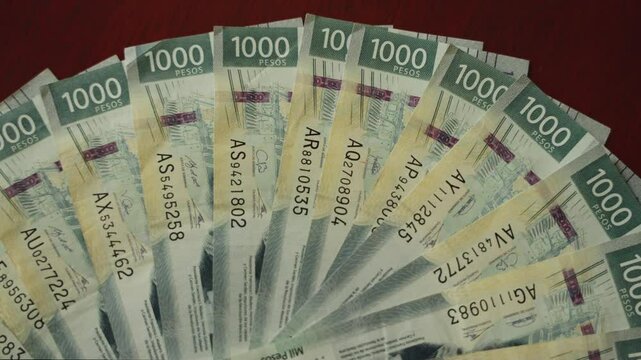 Money $1000 peso bills on a wooden table