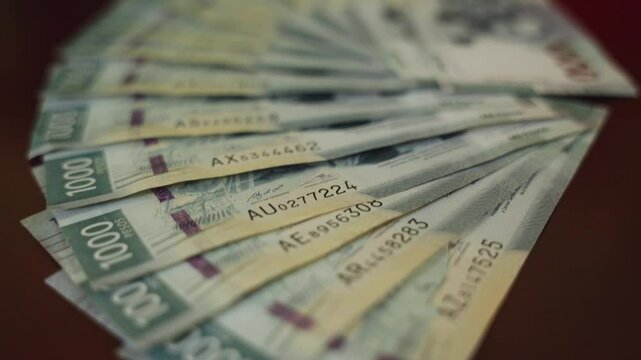 Money $1000 peso bills on a wooden table
