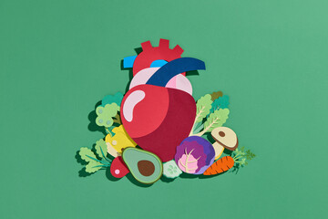 A paper heart surrounded by vegetables, symbolizing a healthy diet
