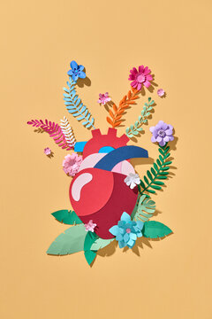 A heart constructed from paper, blooming with floral arrangements