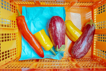 Fresh vegetables in a vibrant orange basket ready for cooking