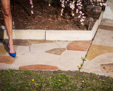 A woman's leg on a sidewalk.