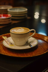 A cup of hot latte with froth art on café counter