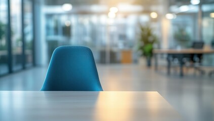 Empty blue chair at a light-colored table in a modern office