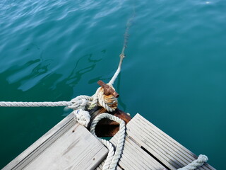 Rusty metal boat mooring post and old rope tied