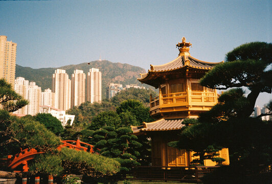 Traditional Chinese pagoda in a landscaped garden with city skyline