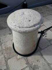 Concrete mooring bollard on shipping dock with ropes tied vertical photo