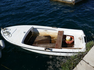 Sinking rowboat full of water and floating debris inside