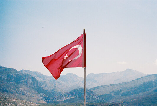 Turkish flag waving with mountains in the background