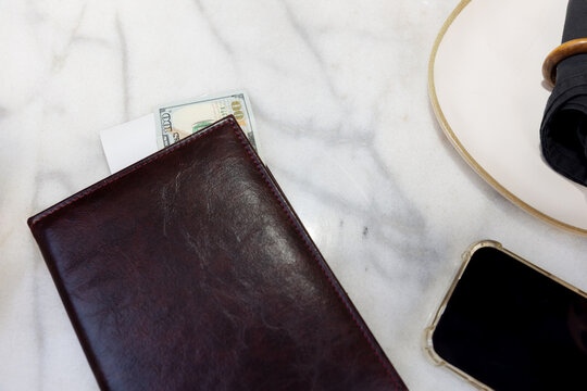 On the table in the restaurant lies a folder with a bill