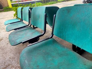 arrangement of green benches that look dirty and dull