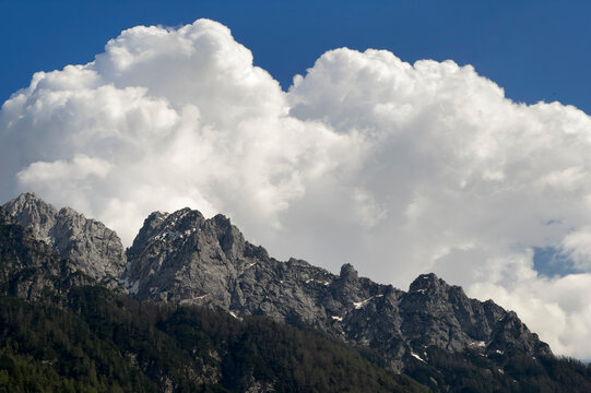 Mountain peak, blue sky and huge white cloud in Kranjska Gora Slovenia
