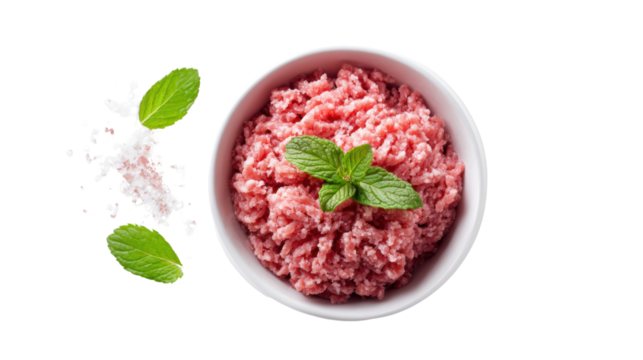 Fresh minced meat with mint leaves in a bowl, sprinkled with salt, white isolated background.