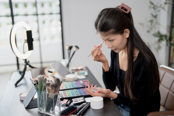 Asia woman beauty influencer makeup artist vlogger live streaming makeup tutorial on smartphone for...