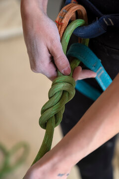 Climber tying knot on harness