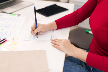 UI UX Designer at Work Asian Woman Hand Sketching Mobile App Interface Wireframe for Website Design...