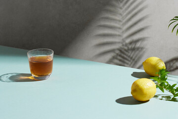 A cozy backdrop with fresh fruits and grass on a table with natural sunlight and shadows.