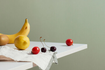 A cozy backdrop with fresh fruits and grass on a table with natural sunlight and shadows.