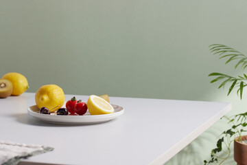 A cozy backdrop with fresh fruits and grass on a table with natural sunlight and shadows.