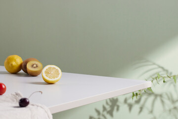 A cozy backdrop with fresh fruits and grass on a table with natural sunlight and shadows.