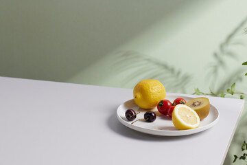 A cozy backdrop with fresh fruits and grass on a table with natural sunlight and shadows.
