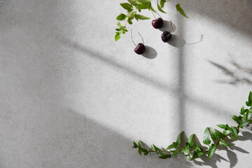 A cozy backdrop with fresh fruits and grass on a table with natural sunlight and shadows.