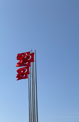 T&uuml;rkiye red flag waving in the air with blue sky background
