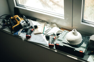 Still life with different worker's tools at window sill.