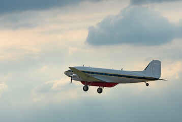 Military plane flying through the sky and clouds on nature background